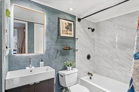 a bathroom with a sink mirror toilet and bathtub