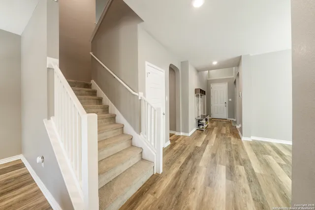 a view of a hallway with wooden floor and entryway