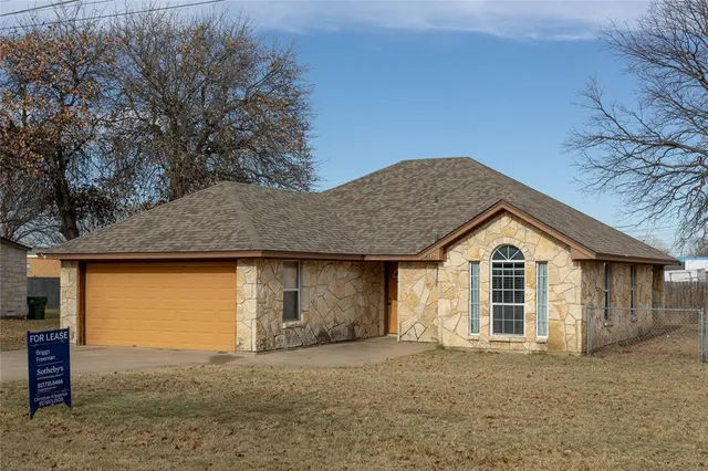 a front view of a house with a garden and garage