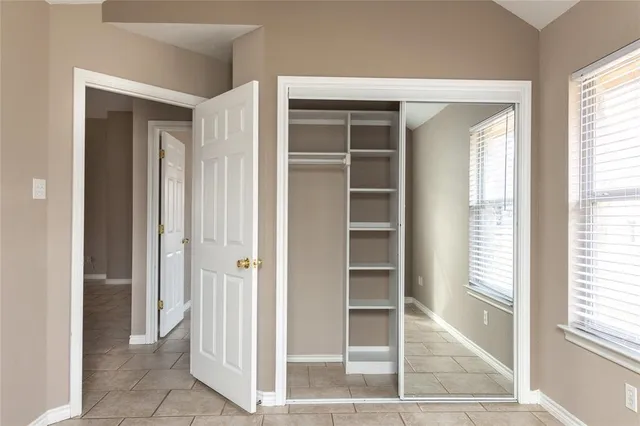 an empty room that has a window and wooden floor