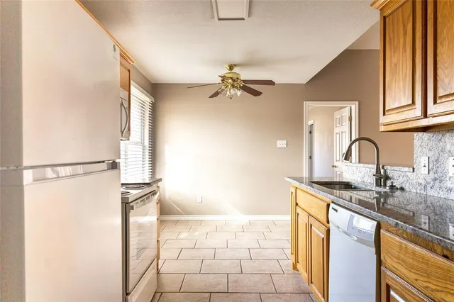 a kitchen with granite countertop cabinets and refrigerator stove