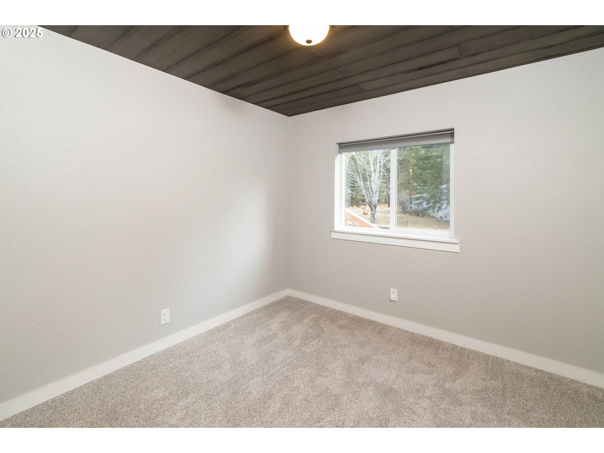 51488 Hann Road La Pine, OR 97739 - Photo 22 of 30 a view of an empty room with wooden floor and a window