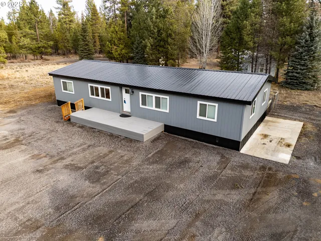 a backyard of a house with table and chairs