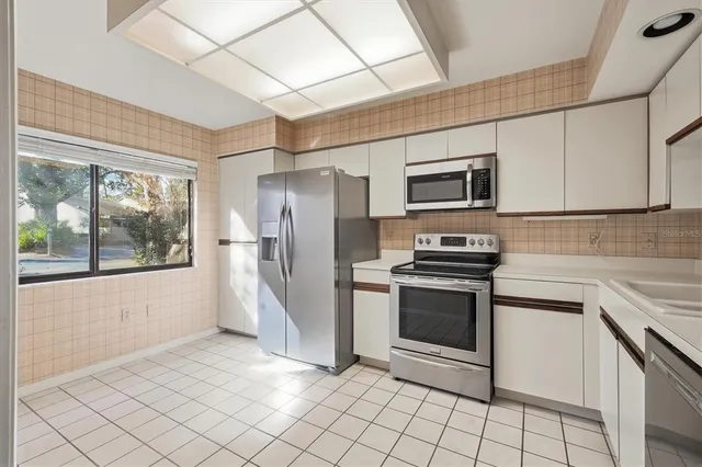 a kitchen with stainless steel appliances a refrigerator sink and microwave