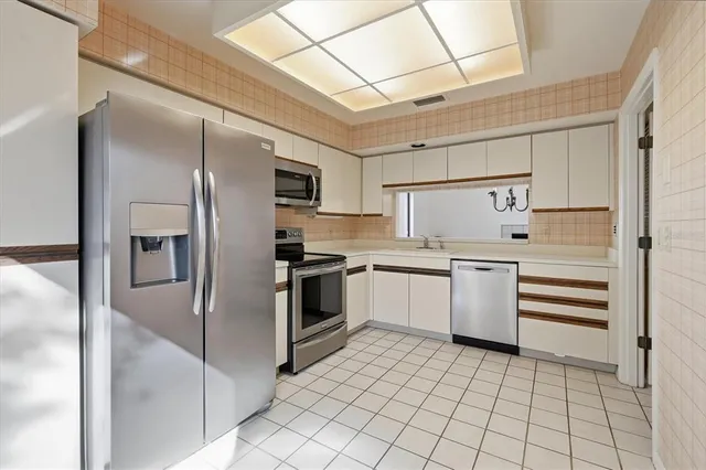 a kitchen with granite countertop white cabinets and white appliances