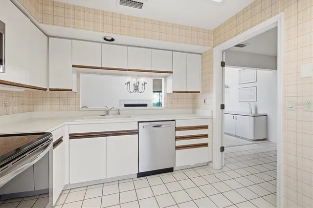 a spacious bedroom with a bed and a chandelier