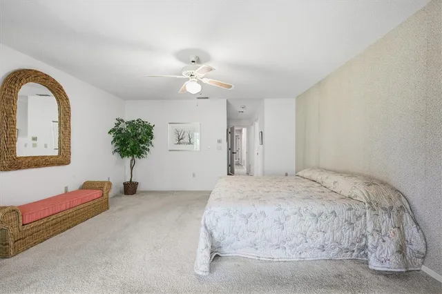 a bed sitting in a spacious bedroom next to a window