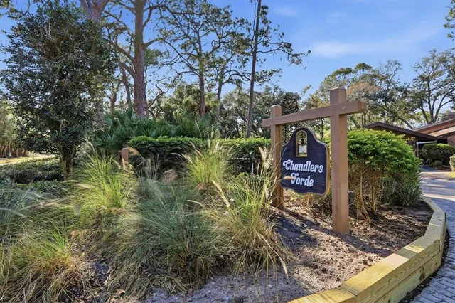 a view of a big house with a big yard plants and large trees