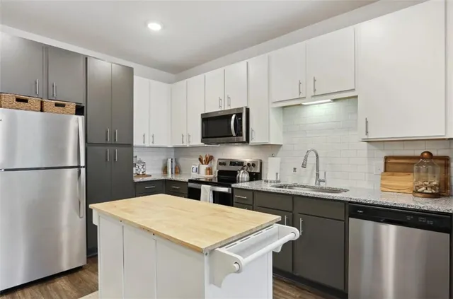 a kitchen with a sink a refrigerator and cabinets