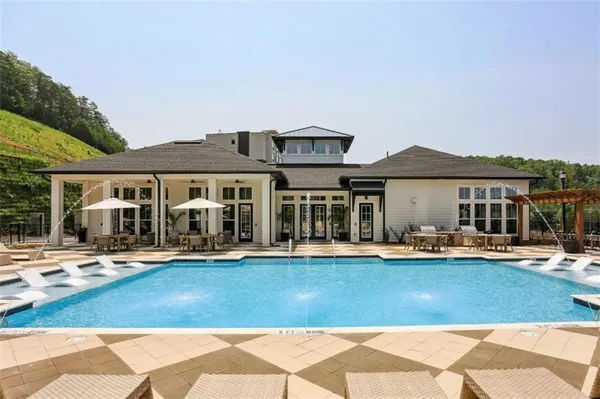 a front view of a house with swimming pool and chairs