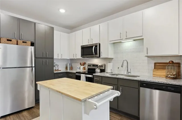 a kitchen with appliances a sink and cabinets