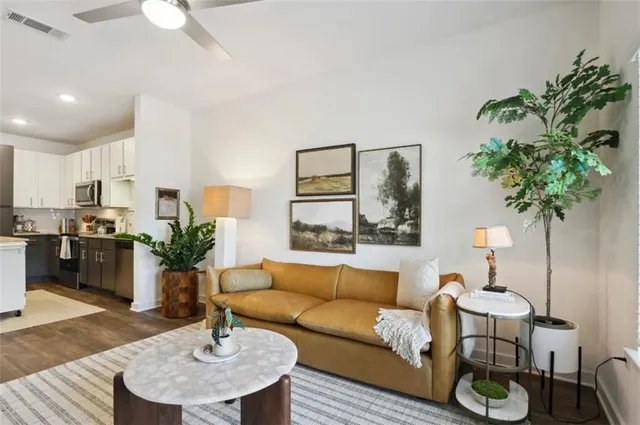 a living room with furniture potted plant and a table