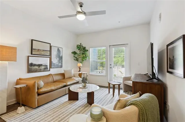 a living room with furniture a large window and a flat screen tv