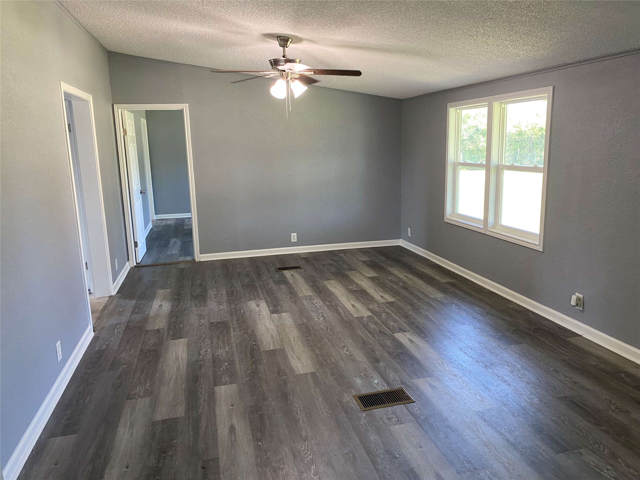 6115 Highway 35 Alvin, TX 77511 - Photo 24 of 49 an empty room with wooden floor chandelier fan and windows