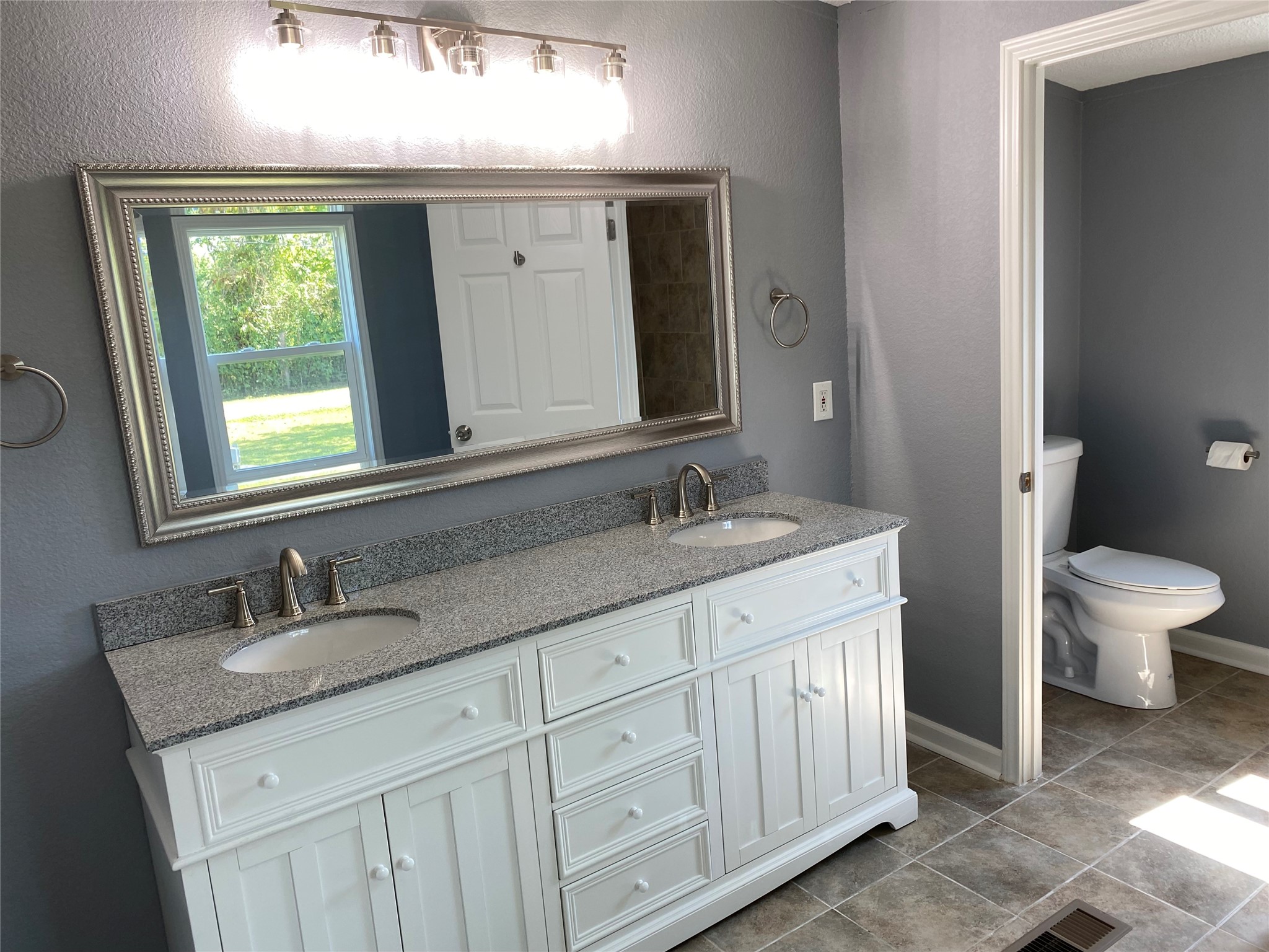 6115 Highway 35 Alvin, TX 77511 - Photo 26 of 49 a bathroom with a granite countertop sink a toilet and a mirror