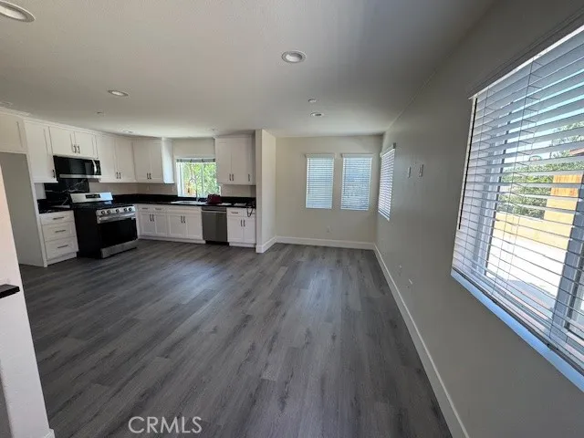 a kitchen with a wooden floor window and cabinets