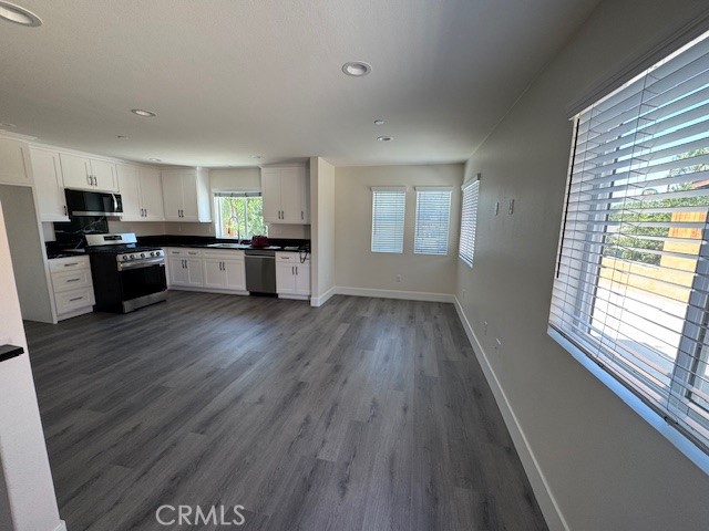 a kitchen with a wooden floor window and cabinets