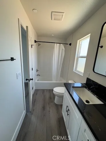 a bathroom with a granite countertop sink toilet a large mirror a vanity and a shower