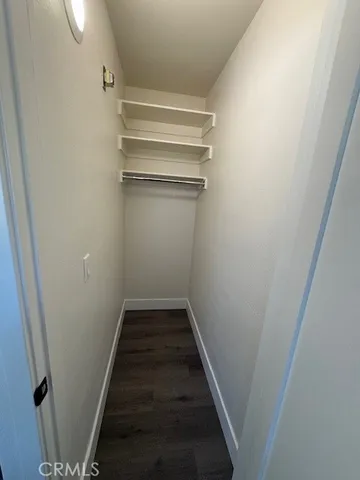 a view of empty room with wooden floor and window