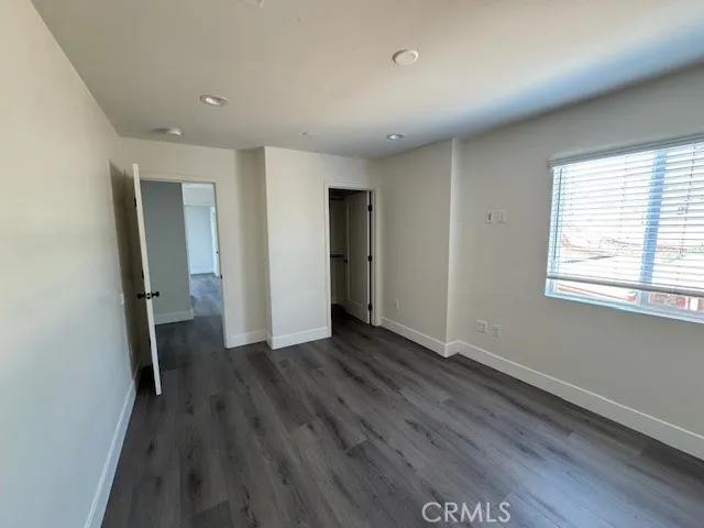 an empty room with wooden floor and a window