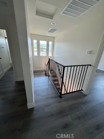 a view of a hallway with wooden floor and windows