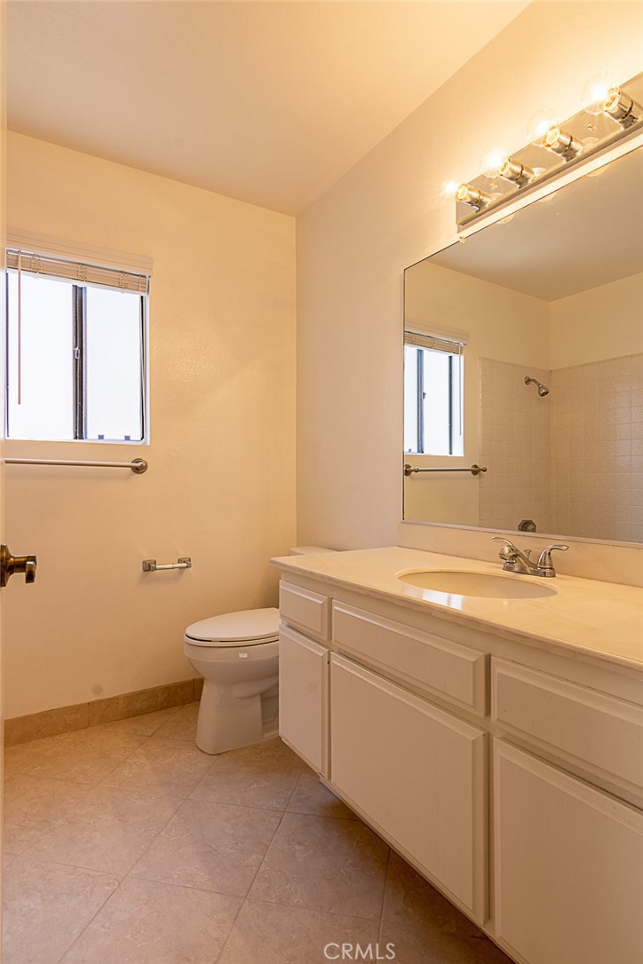 24 Brena Irvine, CA 92620 - Photo 24 of 28 a bathroom with a granite countertop sink a toilet and a mirror