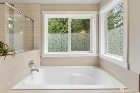 a white bath tub sitting in a bathroom next to a window