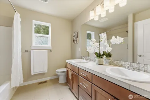 a bathroom with a sink a toilet and a mirror