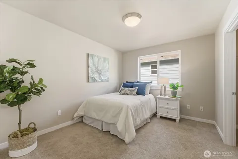 a bedroom with a bed and a potted plant
