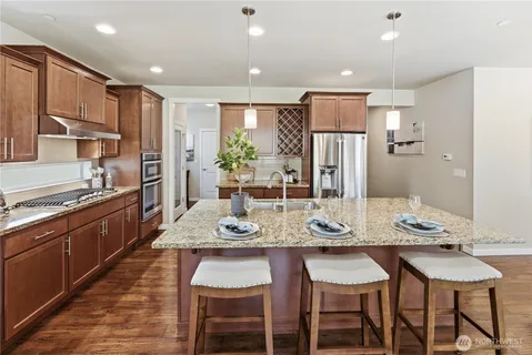 a kitchen with granite countertop a sink stove and refrigerator