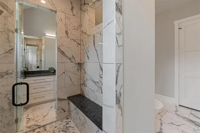 a bathroom with a granite countertop sink a toilet and shower
