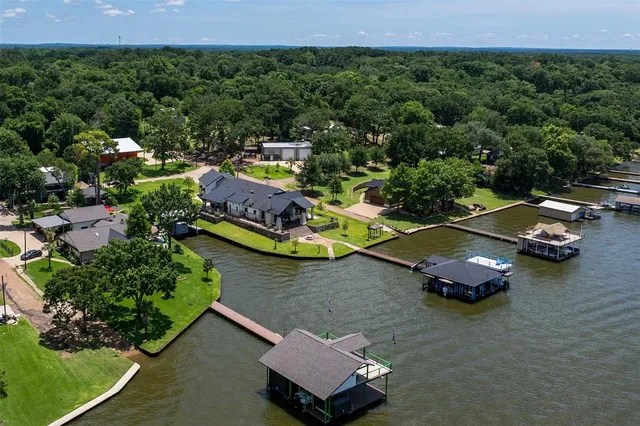 an aerial view of a house with a garden and lake view