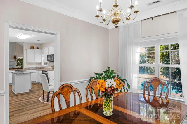 a view of a dining room with furniture a chandelier and wooden floor