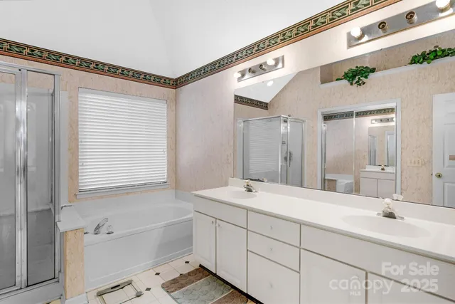 a bathroom with a tub a sink and mirror