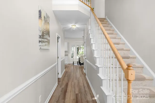 a view of a hallway with wooden floor and staircase
