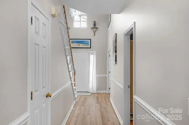 a view of a hallway with wooden floor and entryway
