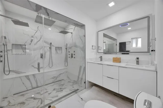 a bathroom with a sink mirror and shower