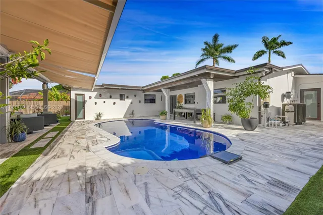 a living room with patio furniture and garden view