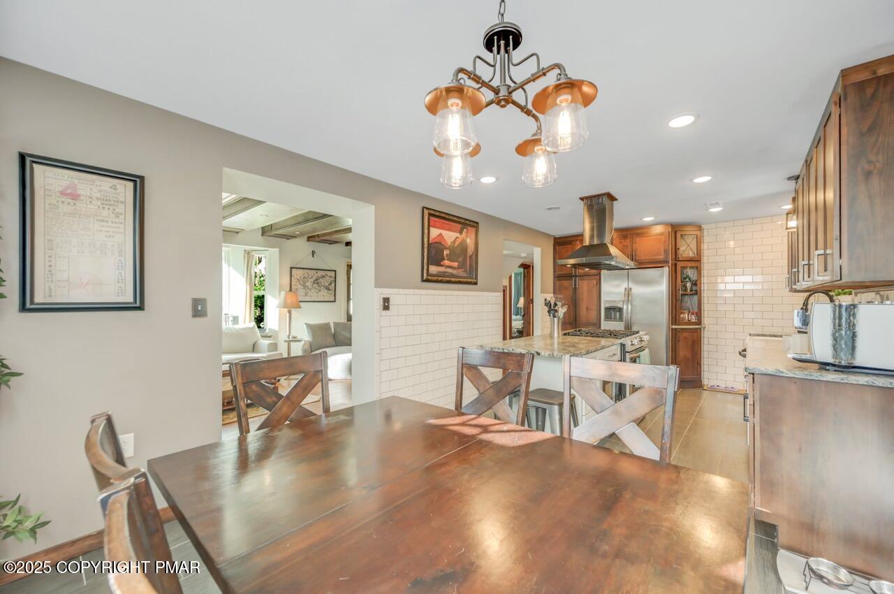 3 Stone Tree Drive Canadensis, PA 18325 - Photo 150 of 201 a dining room with wooden floor a chandelier a wooden table and chairs
