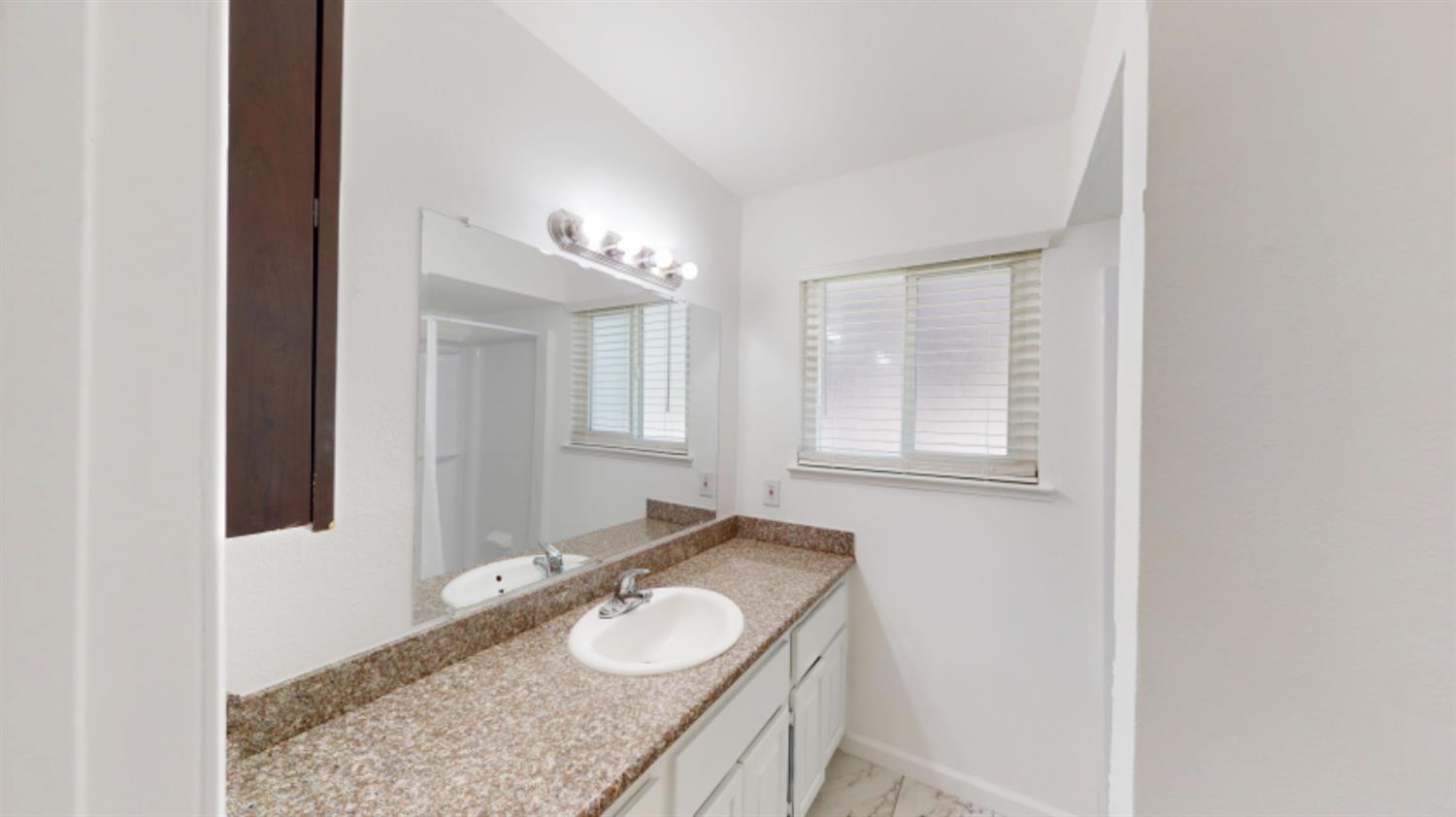 3279 Cherokee Avenue Merced, CA 95340 - Photo 15 of 30 a bathroom with a granite countertop sink and a mirror