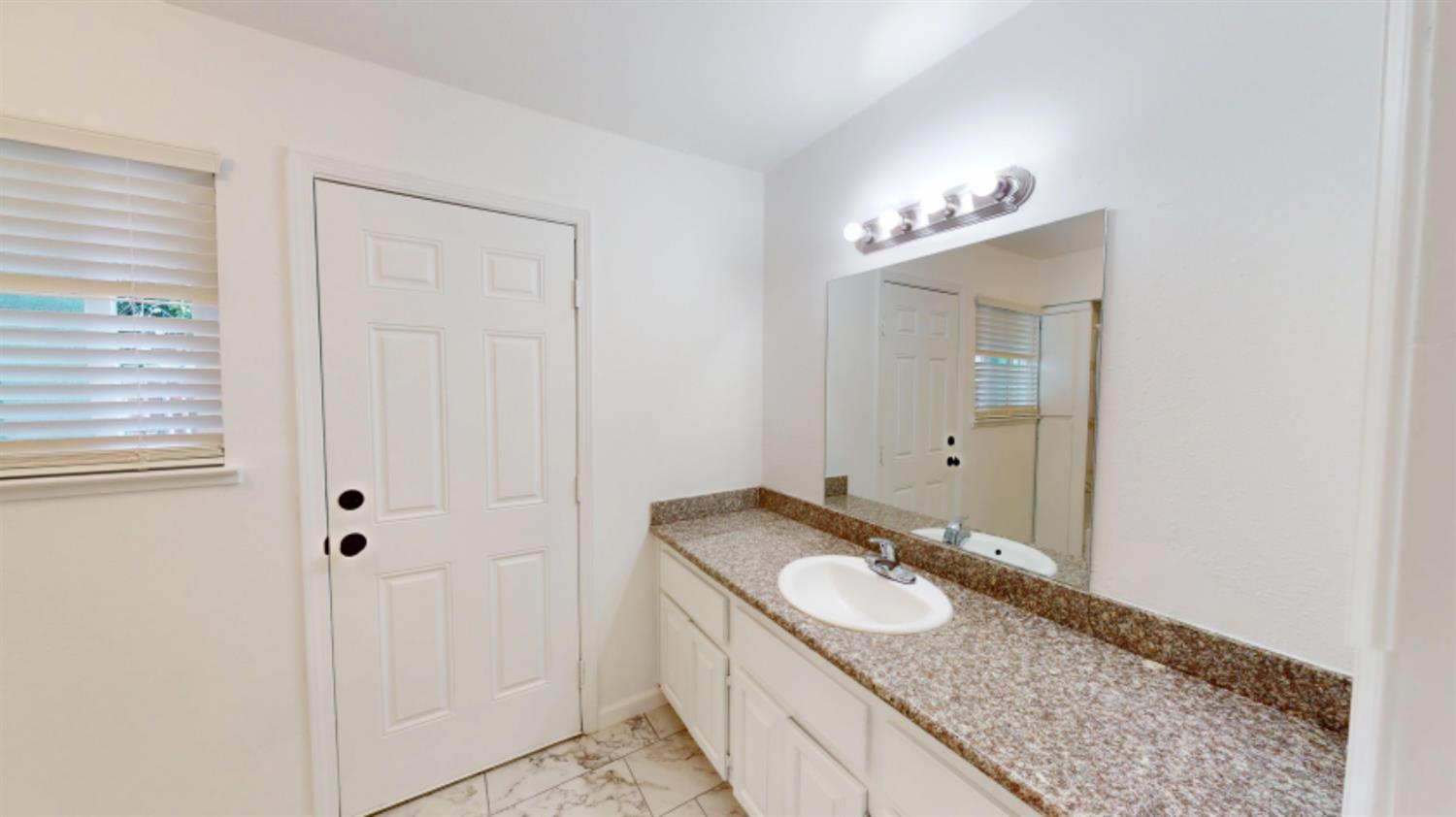 3279 Cherokee Avenue Merced, CA 95340 - Photo 16 of 30 a bathroom with a granite countertop sink and a mirror