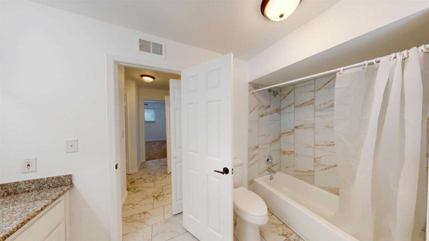 3279 Cherokee Avenue Merced, CA 95340 - Photo 19 of 30 a bathroom with a granite countertop sink toilet and shower