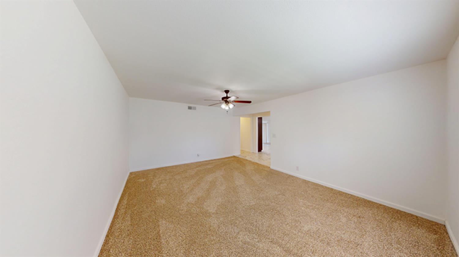 3279 Cherokee Avenue Merced, CA 95340 - Photo 9 of 30 an empty room with a ceiling fan and a window