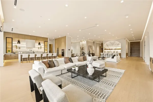 a living room with lots of white furniture and a table