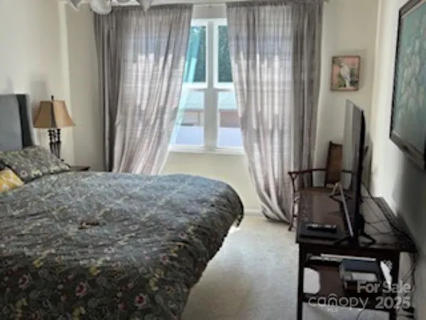 a bedroom with a bed next to a window