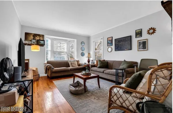 a living room with furniture a couch and a flat screen tv with wooden floor