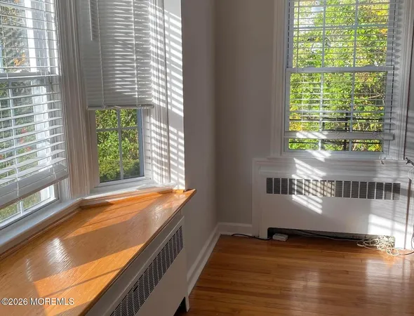 a view of a room with wooden floor and a window