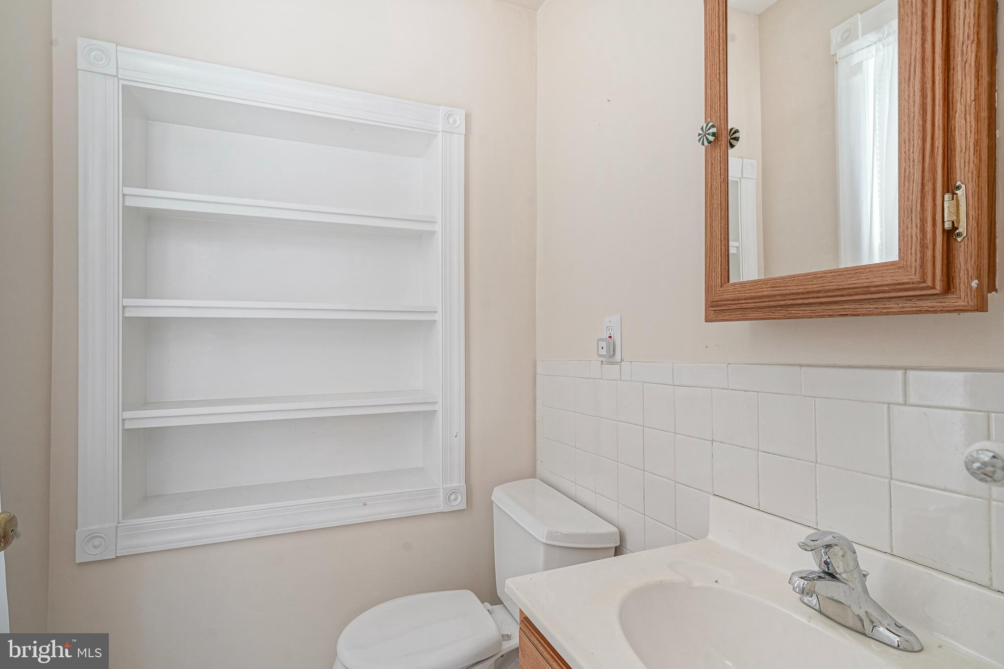 107 Colonial Avenue Haddonfield, NJ 08033 - Photo 13 of 29 a bathroom with a toilet sink a mirror and vanity