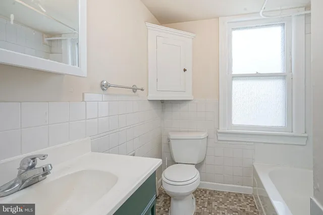 a bathroom with a sink a toilet and a window