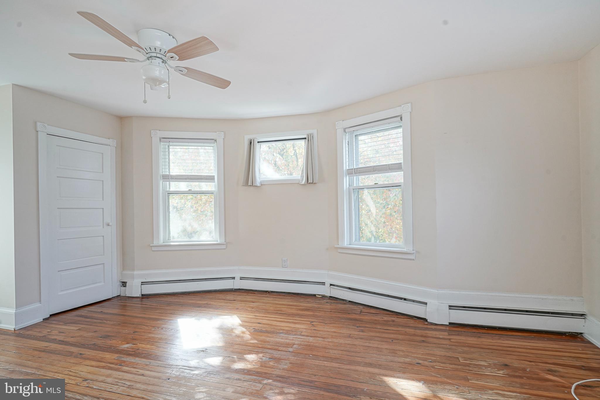 107 Colonial Avenue Haddonfield, NJ 08033 - Photo 25 of 29 an empty room with wooden floor chandelier fan and windows